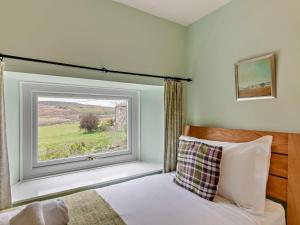 um quarto com uma cama e uma grande janela em 3 Bed in Alnwick 93171 em Edlingham