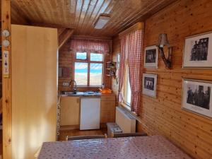 a kitchen with wooden walls and a table in a room at Valhöll Mountain Chalet in Ísafjörður +7 photos