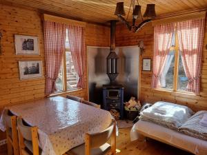 a dining room with a table and a bed and windows at Valhöll Mountain Chalet in Ísafjörður