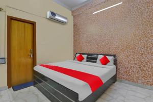 een slaapkamer met een groot bed met rode kussens bij OYO Flagship Hotel New A V Hospitality in Chinhat