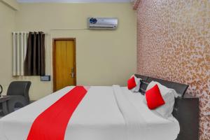 een slaapkamer met een bed met rode kussens erop bij OYO Flagship Hotel New A V Hospitality in Chinhat