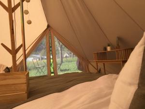 a bedroom with a tent with a bed and a window at Tentes Glamping au camping Le Gerrit à Marsous in Arrens-Marsous