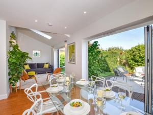 un comedor con mesas y sillas blancas y un patio en 3 Bed in Tenterden 83843 en Saint Michaels
