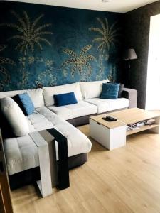 a living room with a white couch and a table at Villa - Les vacances à la Mer in Bray-Dunes