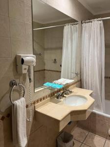 y baño con lavabo y espejo. en Hotel Guerrero en Mar del Plata