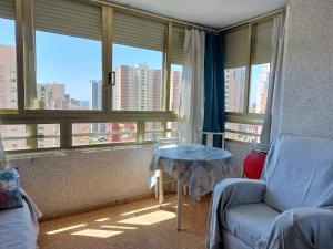 sala de estar con sofá, mesa y ventanas en Apartamento Mariscal 4, 13 con piscina y vistas al mar, en Benidorm