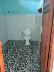 bagno con servizi igienici e pavimento in pietra. di RIUNG LALONG TERONG Guest House a Riung