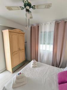 a bedroom with a white bed and a cabinet at Casa Abuela in Málaga