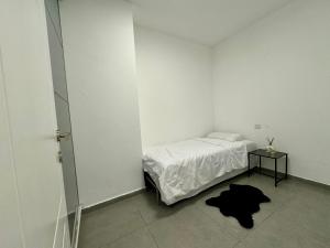 a white room with a bed and a table at מיני דירת פנטהאוז in Rishon LeẔiyyon