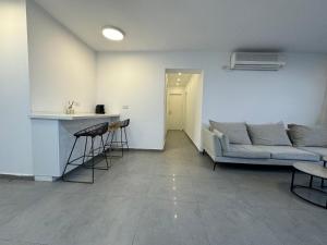 a living room with a couch and a table at מיני דירת פנטהאוז in Rishon LeẔiyyon +3 photos