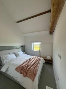 a bedroom with a large bed and a window at The Hayloft, Modern 4 Bed, 8 person, Barn Conversion in a Rural Location with Great Access in Silkstone