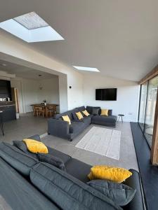 a living room with a couch and a tv at The Hayloft, Modern 4 Bed, 8 person, Barn Conversion in a Rural Location with Great Access in Silkstone