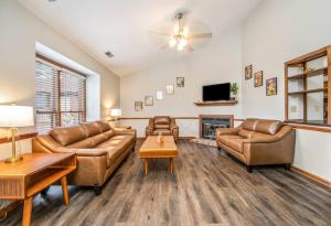 Una sala de estar con muebles de cuero y chimenea. en The Homeplace Abode, en Fayetteville