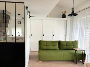 a living room with a green couch and white cabinets at GOODMOOSE - Good Mood House in Palanga