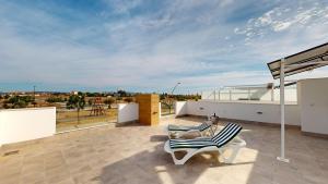 a patio with a chair and a table on a roof at Villa Solar - A Murcia Holiday Rentals Property in Roldán