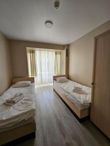 two twin beds in a room with a window at Біля Замку in Lviv
