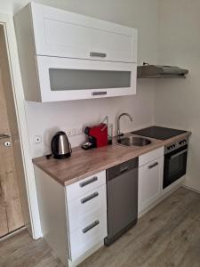 a small kitchen with white cabinets and a sink at Ferienwohnung Diemel in Bad Karlshafen