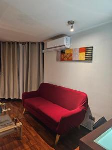 un soggiorno con divano rosso in una camera di San Ignacio Suite Apartments a Santiago