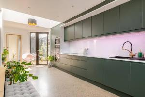 a kitchen with green cabinets and a sink at Cozy room in Stoneybatter, Dublin in Dublin