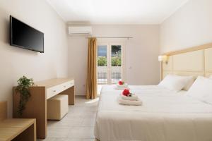 a hotel room with two beds and a television at Santos Luxury Apartments in Dassia +59 photos