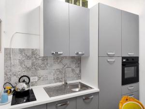 a kitchen with white cabinets and a sink at A ca de RITA in Albenga