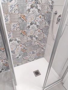 a shower with a tiled wall in a bathroom at A ca de RITA in Albenga