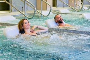 two people in the water in a swimming pool at Casa Raquel Montanejos in Montanejos