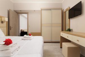 Un dormitorio con una cama blanca con toallas. en Santos Luxury Apartments, en Dassia