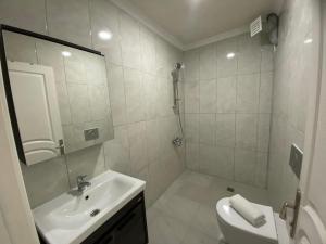 a white bathroom with a sink and a shower at Ayvalık Denizyıldızı Otel in Ayvalık