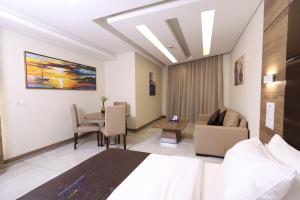 une chambre d'hôtel avec un lit, une table et des chaises dans l'établissement Ibiza Hotel, à Jounieh
