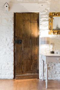 een houten deur in een kamer met een tafel bij Romantic Little House near Bath in Rode