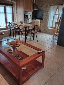 un soggiorno con tavolo e alcune sedie di Niko's Stone Guest House a Plitra