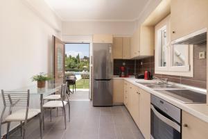 a kitchen with a stainless steel refrigerator and a table at Santos Luxury Apartments in Dassia
