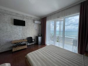 una camera da letto con un letto, una scrivania e una finestra di Hotel Sunlight a Kobuleti