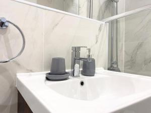 um lavatório branco com uma torneira e um espelho em Cloud at Fleet Heights Apartment Two em Fleet