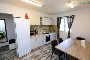 a kitchen with a wooden table and a dining room at Vezda 19 in Orşova