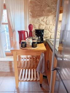 una cucina con tavolo in legno e tazze di Niko's Stone Guest House a Plitra