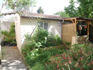 uma pequena casa com um portão e um jardim em La maison aux bambous em Montreuil