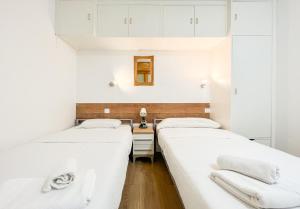 two beds in a small room with white walls at Apartamento reformado Central park en el centro de Andorra in Escaldes-Engordany
