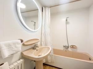 a bathroom with a sink and a mirror and a tub at Apartamento reformado Central park en el centro de Andorra in Escaldes-Engordany