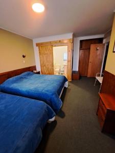 Habitación de hotel con 2 camas y baño en Hotel Condor de Plata, en Punta Arenas