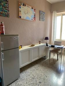 a kitchen with a counter with a refrigerator and a table at Casa Melany in Taormina