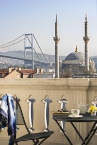 a table on a balcony with a view of a bridge at Nevv Bosphorus Hotel in Istanbul