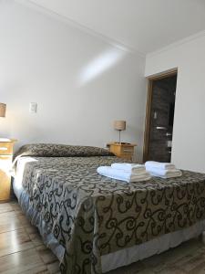 Una habitación de hotel con una cama con toallas. en Hotel Geminis en Mendoza