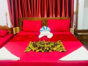 ジャフナにあるSt Anne's Hotel & Restaurantの赤いベッド(ドレス、弓付)