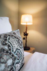 ein Schlafzimmer mit einem Bett mit einem Kissen und einer Lampe in der Unterkunft La Villa d'Andrea in Ramatuelle