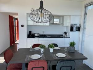 einen Esstisch mit Stühlen und eine Küche in der Unterkunft Strand Chalet am IJsselmeer Haus 214 in Enkhuizen