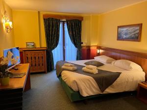 um quarto de hotel com uma cama com toalhas em Hotel De Champoluc em Champoluc