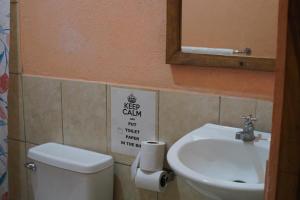 a bathroom with a toilet and a sink and a mirror at Casa de Gio in Moyogalpa