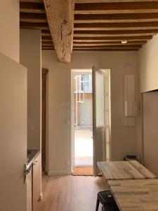 - une cuisine avec une table et une porte menant à une chambre dans l'établissement Hôtel Des Docks, à Digoin